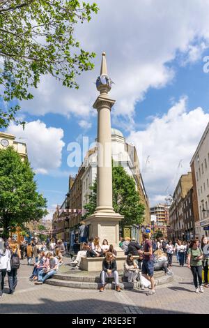 Menschen genießen die Sonne rund um Seven Dials in der Nähe von Covent Garden im Zentrum von London. Stockfoto