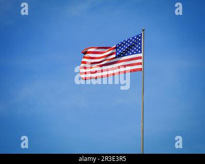 Blick aus dem niedrigen Winkel auf die amerikanische Flagge vor blauem Himmel Stockfoto