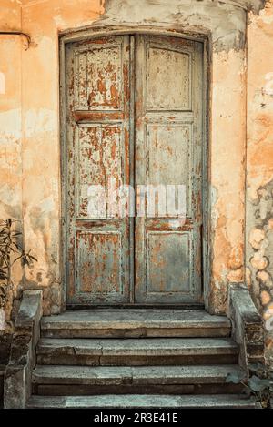 Alte, abgenutzte Holztür eines verlassenen Hauses. Stockfoto