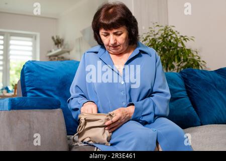 Die ältere Frau sucht etwas in der Handtasche Stockfoto