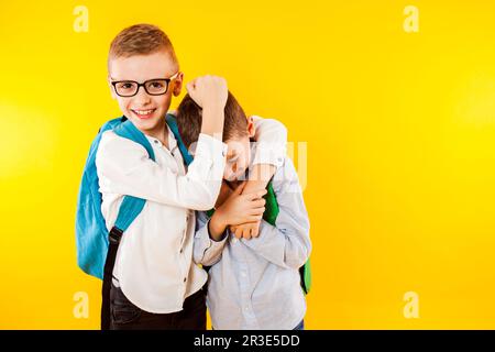 Die kleinen Schüler haben Spaß und zeigen ihre Kraft Stockfoto