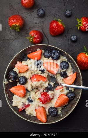 Das Konzept eines gesunden Frühstücks mit Haferflocken mit Erdbeeren und Heidelbeeren Stockfoto