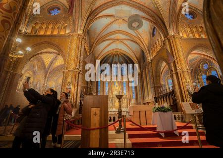 Budapest, Ungarn - 26. November 2022: Touristen am Altar der Matthiaskirche, des Buda-Hügels, Budapest, Ungarn. Stockfoto