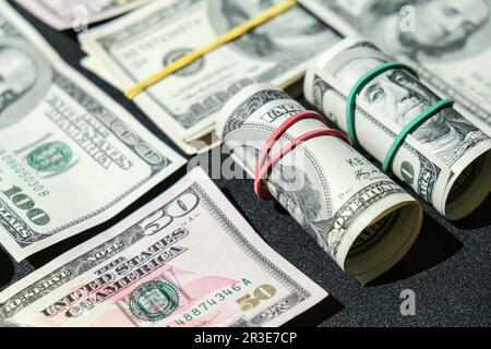 US-Dollar-Bündel, isoliert auf Dollarbasis. Papierstückelungen von Dollarrollen mit Gummibändern. Geschäftlich Stockfoto