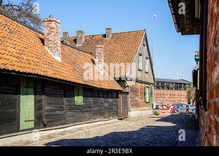 Blick auf die Altstadt von Liepaja mit alten Holzhäusern mit Tonziegeldächern, vielen Schornsteinen und blauem Himmel Stockfoto