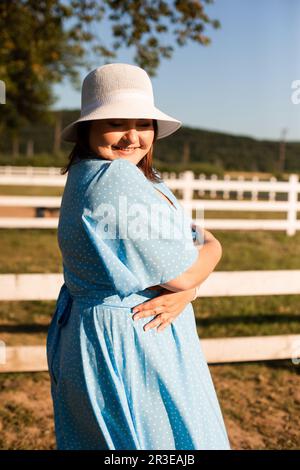 Ehrliche Frau im Hut auf dem Ackerland genießen Sie den Sommer Stockfoto