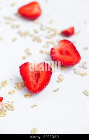 Haferbrei mit frischen Erdbeeren auf einem hellen Tisch. Gesundes Frühstück, veganisches oder vegetarisches Speisekonzept. Essen im Hintergrund Stockfoto