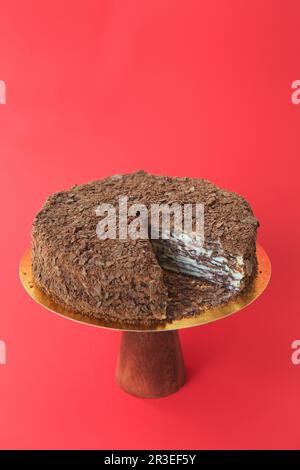 Geschnittener Geburtstagskuchen auf dem hölzernen Kuchenstand. Wunderschöner Schwammkuchen auf dem Papierhintergrund. Kopieren en Stockfoto