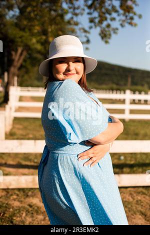 Ehrliche Frau im Hut auf dem Ackerland genießen Sie den Sommer Stockfoto