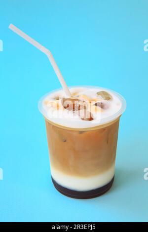 Ein Glas mit Eiskaffee-Cocktail, kühles Erfrischungsgetränk oder ein Getränk mit Eis auf Blau Stockfoto