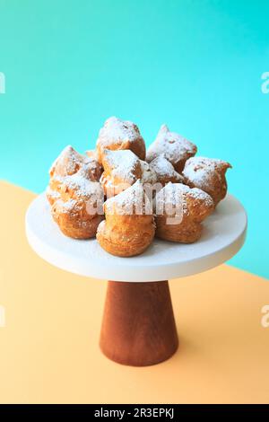 Hausgemachte Profiteroles mit Puderzucker. Creme Puffs füllten Vanille-Vanille und waren mit Eiscreme bedeckt Stockfoto