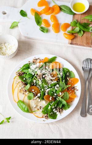 Spinat und Quinoa Salat mit Birnen, Orangen und Ricotta. Gesunde Mahlzeit Vorbereitung. Pflanzliche Gerichte. Grün leben. Veganes Rezept. Foo Stockfoto