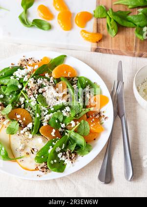 Spinat und Quinoa Salat mit Birnen, Orangen und Ricotta. Gesunde Mahlzeit Vorbereitung. Pflanzliche Gerichte. Grün leben. Veganes Rezept. Foo Stockfoto