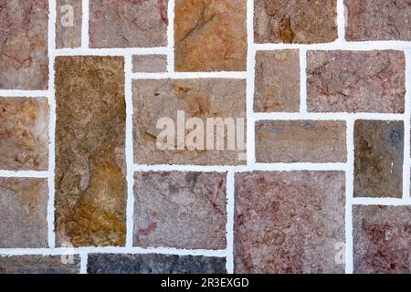 Hintergrund einer Steinmauer aus rechteckigen Ziegeln Stockfoto