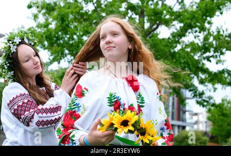 Schönes junges Teenager Mädchen im Kranz für ukrainischen Urlaub mit Freund kommuniziert Ort für Werbetext ukrainische Tradition einen Kranz auf den Kopf legen Flechten Zöpfe bestickte Hemden Stockfoto