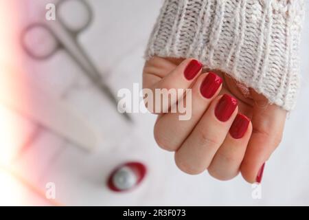 Stylische rote Nägel für Frauen. Moderne, wunderschöne Maniküre. HerbstwinterNageldesign-Konzept der Schönheitsbehandlung. Gelnägel. Hautpflege Stockfoto
