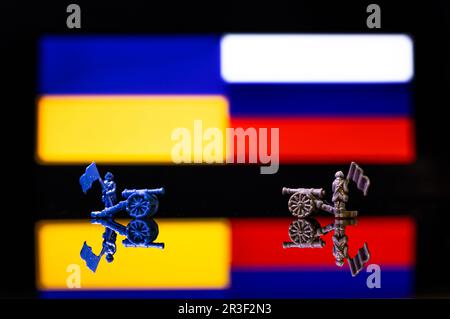 Konzeptionelles Bild des Krieges zwischen Russland und der Ukraine mit Spielzeugsoldaten und Nationalflaggen Stockfoto