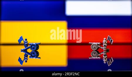Konzeptionelles Bild des Krieges zwischen Russland und der Ukraine mit Spielzeugsoldaten und Nationalflaggen Stockfoto