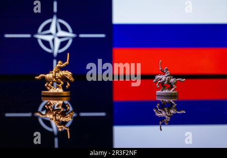 Konzeptionelles Bild des Krieges zwischen Russland und der NATO mit Spielzeugsoldaten und Nationalflaggen Stockfoto