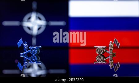 Konzeptionelles Bild des Krieges zwischen Russland und der NATO mit Spielzeugsoldaten und Nationalflaggen Stockfoto