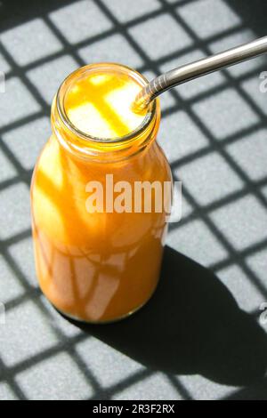 Saisonale Kürbis Karotten Smoothie Drink Detox Frühstück. Saubere Ernährung, Gewichtsverlust, gesunde Ernährung Konzept. Trendige Schatten Stockfoto