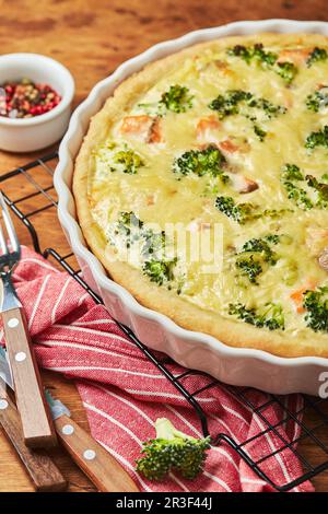 Hausgemachte Quiche mit rotem Fisch, Lachs, Brokkoli und Käse auf Holzhintergrund Stockfoto