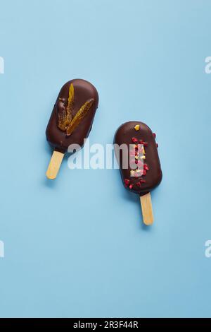 Mousse-Dessert mit Fruchtaromen in Form von Eiscreme auf blauem Hintergrund. Stockfoto