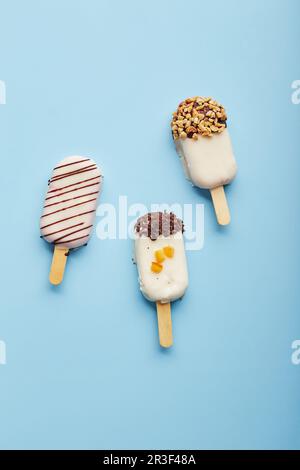 Mousse-Dessert mit Fruchtaromen in Form von Eiscreme auf blauem Hintergrund. Stockfoto