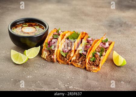 Traditionelle mexikanische Birria Consome Suppe und vier Taco mit Rindfleisch Stockfoto