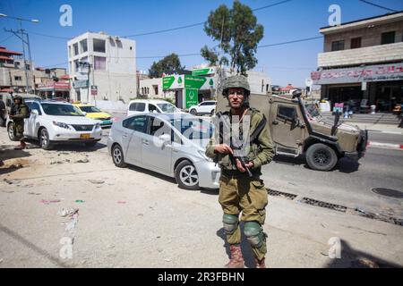 Nablus, Palästina. 23. Mai 2023. Israelische Soldaten bewachen das Auto eines israelischen Siedlers, nachdem es in einer Hawara-Stadt südlich von Nablus im besetzten Westjordanland mit Steinen bewacht wurde. Zwei israelische Siedler wurden verletzt, nachdem palästinensische Jugendliche in der Stadt Hawara Steine nach ihrem Auto warfen, während sie vorbeifuhren. (Foto von Nasser Ishtayeh/SOPA Images/Sipa USA) Guthaben: SIPA USA/Alamy Live News Stockfoto