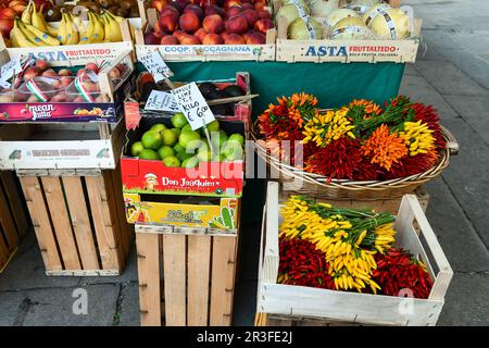 Nahaufnahme eines Obst- und Gemüsestands mit Chili, Melonen und Pfirsichen auf dem Rialto-Markt im Sommer, Venedig, Venetien, Italien Stockfoto