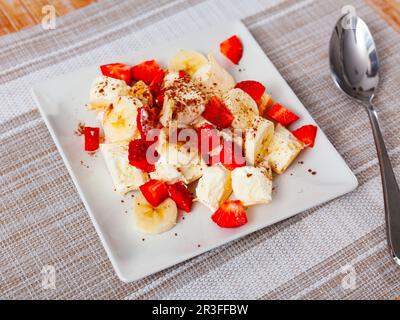 Portion Eis mit geschnittenen Erdbeeren und Bananen Stockfoto