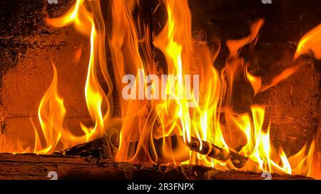 Feuerflammen und heiße Kohlen von verbranntem Holz im Kamin Stockfoto