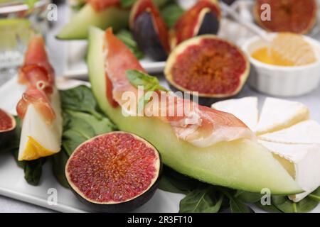 Leckere Melone, Jamon und Feigen, serviert auf weißem Teller, Nahaufnahme Stockfoto