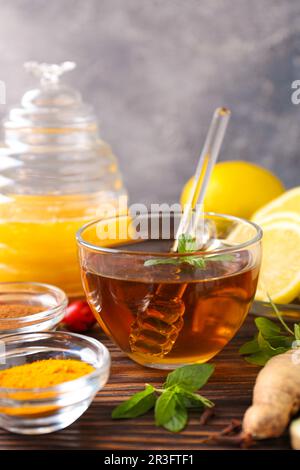 Tee mit Honig und Zutaten auf einem Holztisch Stockfoto