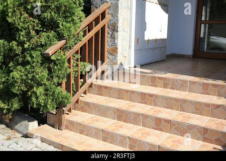 Blick auf wunderschöne Steintreppen mit Metallgeländer in der Nähe des Hauses im Freien Stockfoto