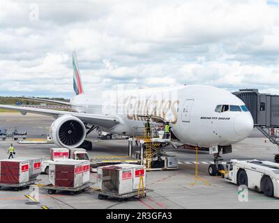 Gardermoen, Norwegen - 22. August 2022: Emirates Boeing 777-300ER an einem Tor des Flughafens Oslo, Gardermoen, wird mit Fracht- und Gepäckcontainern beladen Stockfoto