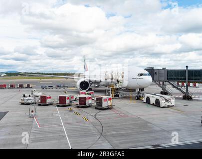 Gardermoen, Norwegen - 22. August 2022: Emirates Boeing 777-300ER an einem Tor des Flughafens Oslo, Gardermoen, wird mit Fracht- und Gepäckcontainern beladen Stockfoto