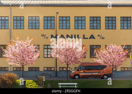Blühende Kirschbäume vor dem Manilla-Firmengebäude in Turku Finnland Stockfoto