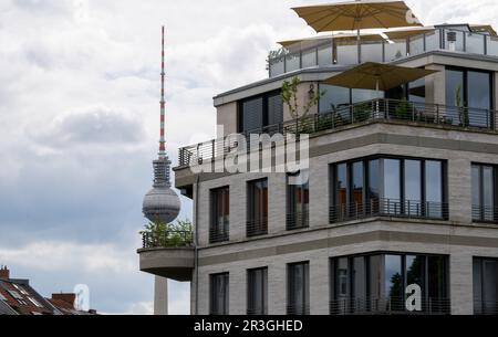 Berlin, Deutschland. 19. Mai 2023. Der Fernsehturm erhebt sich in den Himmel vor dem Hintergrund eines luxuriösen Neubaus im Berliner Stadtteil Prenzlauer Berg. Kredit: Monika Skolimowska/dpa/Alamy Live News Stockfoto