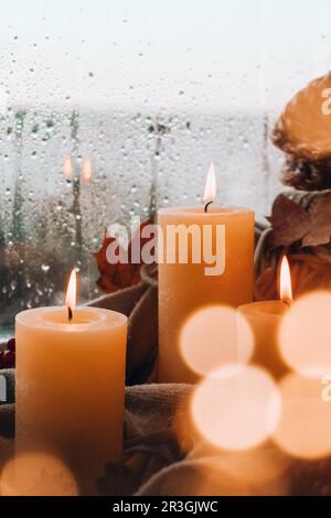 Hallo Herbst, wir feiern die Herbstferien im gemütlichen Haus auf dem Fenstersill Hygge Atmosphäre Thanksgiving Blätter, Gewürze und Kerze o Stockfoto