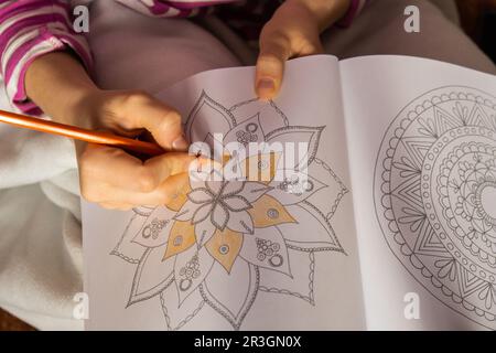 Weibliche Malmandalas Anti-Stress-Seite gegen Stress. Entspannendes psychisches Wohlbefinden und Kunsttherapie. Frau malt Skizze, Stockfoto