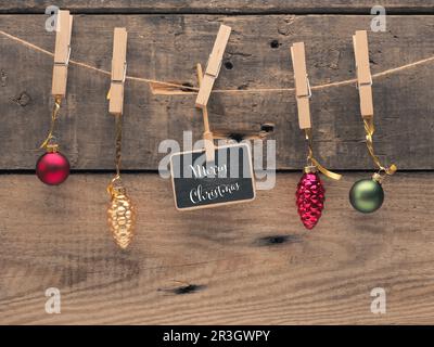 Bunte Weihnachtsbälle auf einer Linie mit einer kleinen Tafel. Hintergrund für Weihnachtskarte oder Einladung Stockfoto