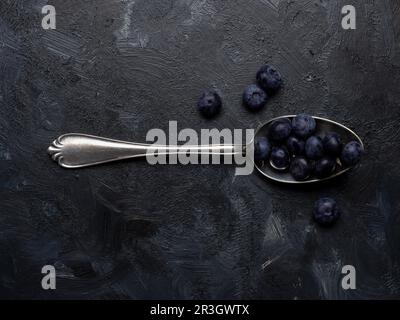 Frische Bio-Heidelbeeren auf einem silbernen Löffel auf dunklem Hintergrund, super Essen, gesunde Ernährung, Antioxidantien Stockfoto