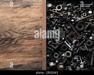 Alte rostige Schrauben und Muttern in einer Holzkiste auf einer Werkbank Stockfoto