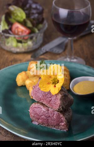 Steak mit Kroketten auf Holz Stockfoto