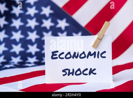 Die Nationalflagge der USA. Amerikanischer Flaggen- und Papiertext: ÖKONOMISCHER SCHOCK. Globaler Hunger, Inflation, hohe Preise, Incre Stockfoto