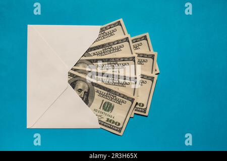 Dollar-Banknote spart Geld in Umschlägen auf blauem Hintergrund. Konsum und Sparsamkeit beim Geldsammeln. Tipps. Geschäftlich Stockfoto
