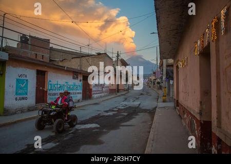 23. Mai 2023, Mexiko, San Nicolás de los Ranchos: Die Bewohner fahren ein Quad, während der Vulkan Popocatepetl im Hintergrund Asche, Dampf und Gas emittiert. Popocatépetl ist einer der aktivsten Vulkane in Mexiko. Seit Tagen gibt es Asche, Dampf und Gas aus. Die Experten gingen jedoch davon aus, dass die vulkanische Aktivität begrenzt sein wird, wie von der Behörde für Katastrophenschutz berichtet wurde. Foto: Celacanto/ Stockfoto