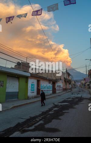 23. Mai 2023, Mexiko, San Nicolás de los Ranchos: Ein Bewohner wandert auf einer Straße, während der Vulkan Popocatepetl im Hintergrund Asche, Dampf und Gas emittiert. Popocatépetl ist einer der aktivsten Vulkane in Mexiko. Seit Tagen gibt es Asche, Dampf und Gas aus. Die Experten gingen jedoch davon aus, dass die vulkanische Aktivität begrenzt sein wird, wie von der Behörde für Katastrophenschutz berichtet wurde. Foto: Celacanto/ Stockfoto